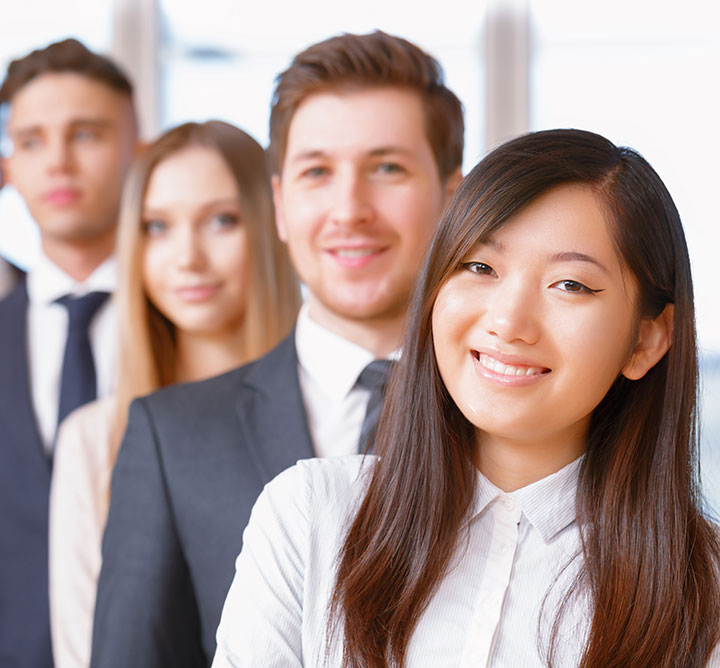 A diverse group of young professionals smiling.