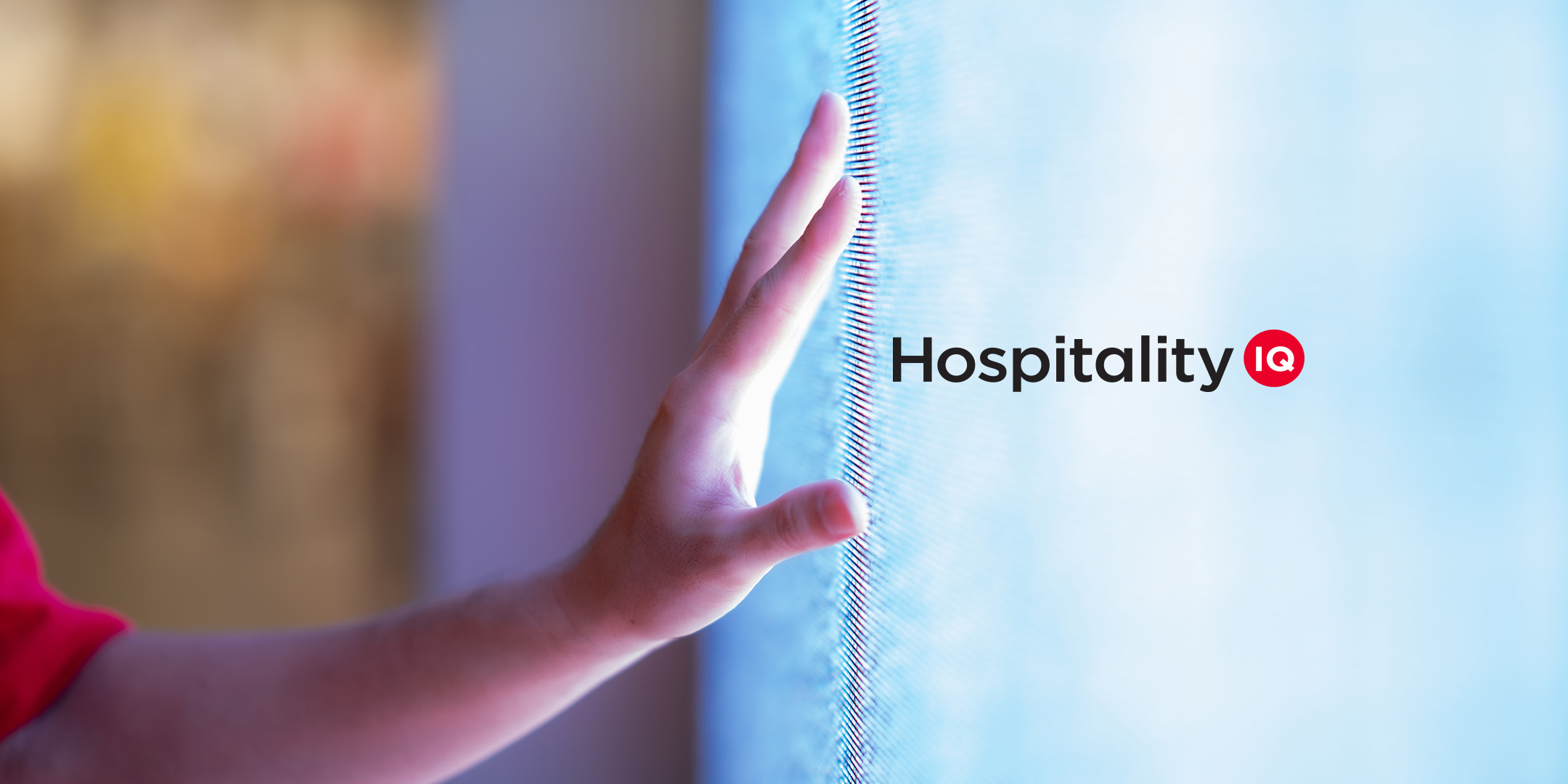 A hand touching a glowing screen with the logo for Hospitality IQ.