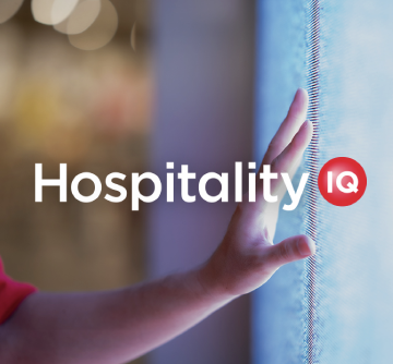 A hand touching a glowing screen with the logo for Hospitality IQ.
