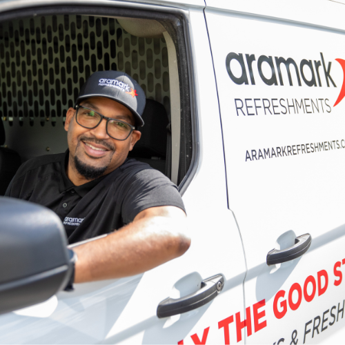 An aramark worker smiling in a van.