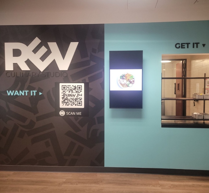 A ghost kitchen setup for REV Culinary Studio, with a scannable QR code and delivery window.