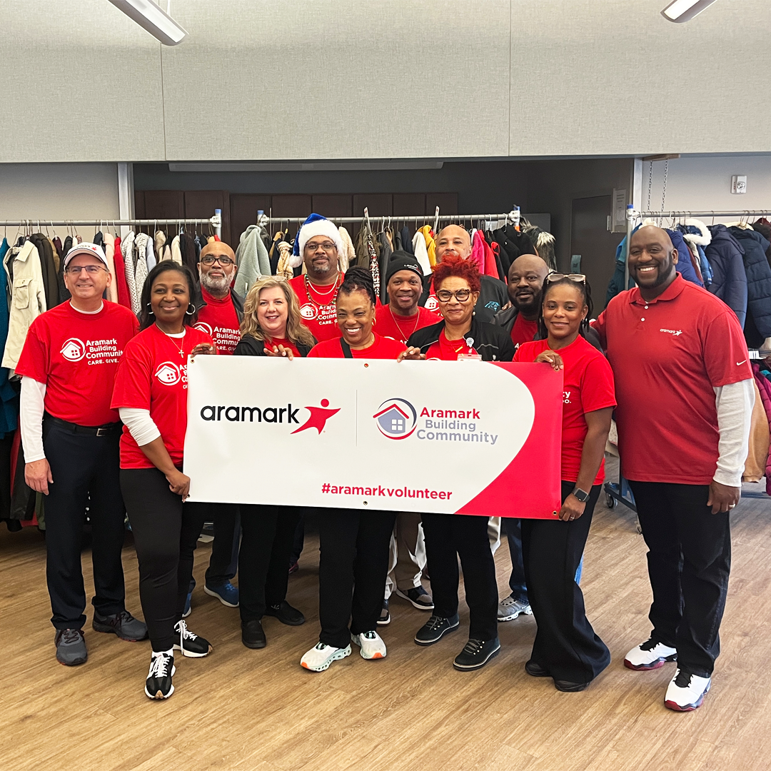 healthcare+ volunteers in front of clothing racks