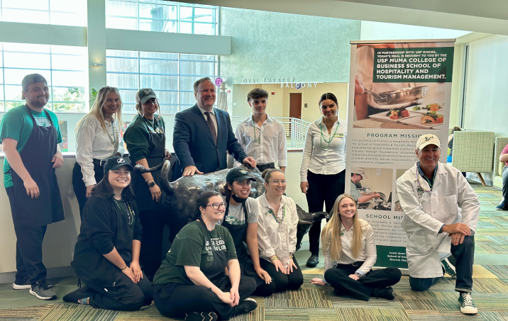 hospitality students posing with school dean