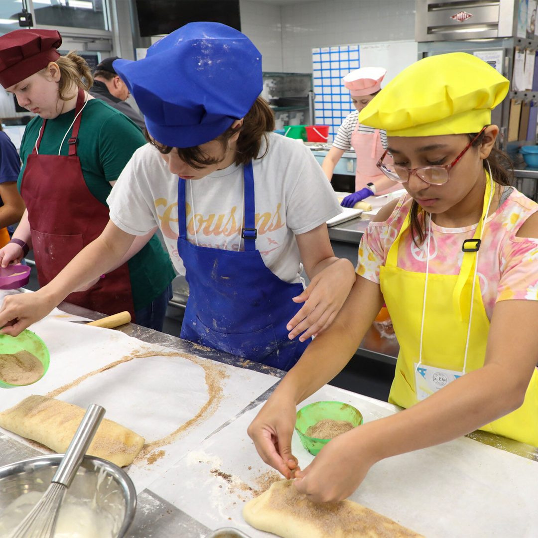 Students preparing food in a kitchen.