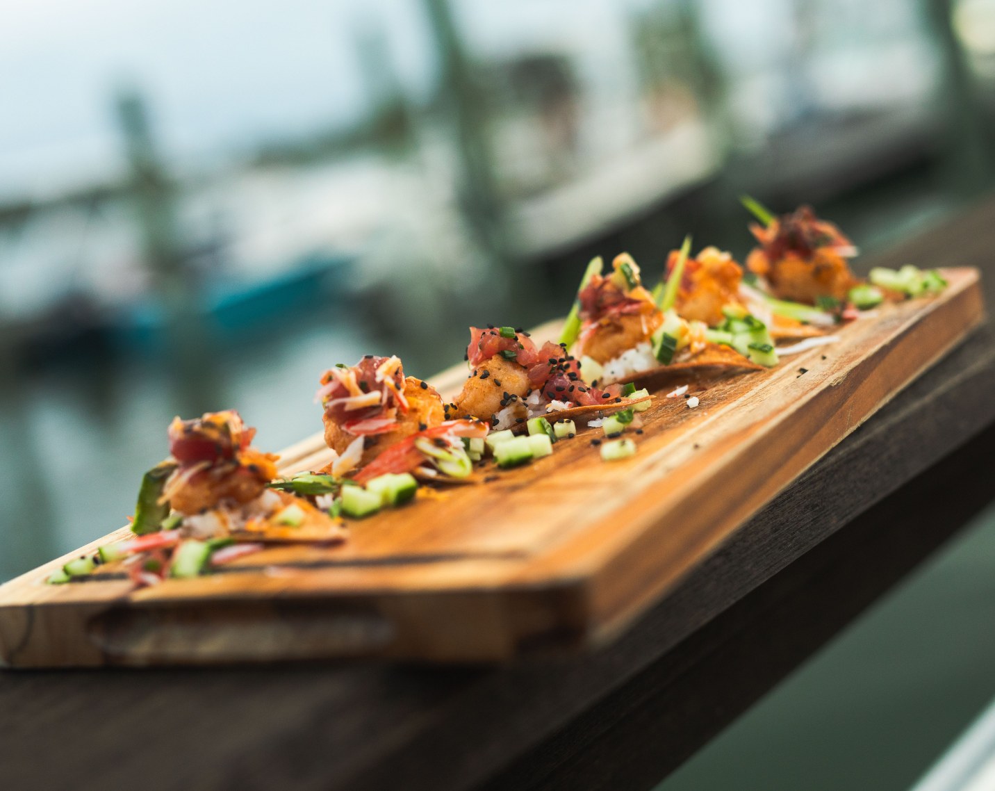 Sushi Nachos with baked wontons, sushi tuna, baby shrimp, chives, English cucumber, sriracha, and eel sauce.