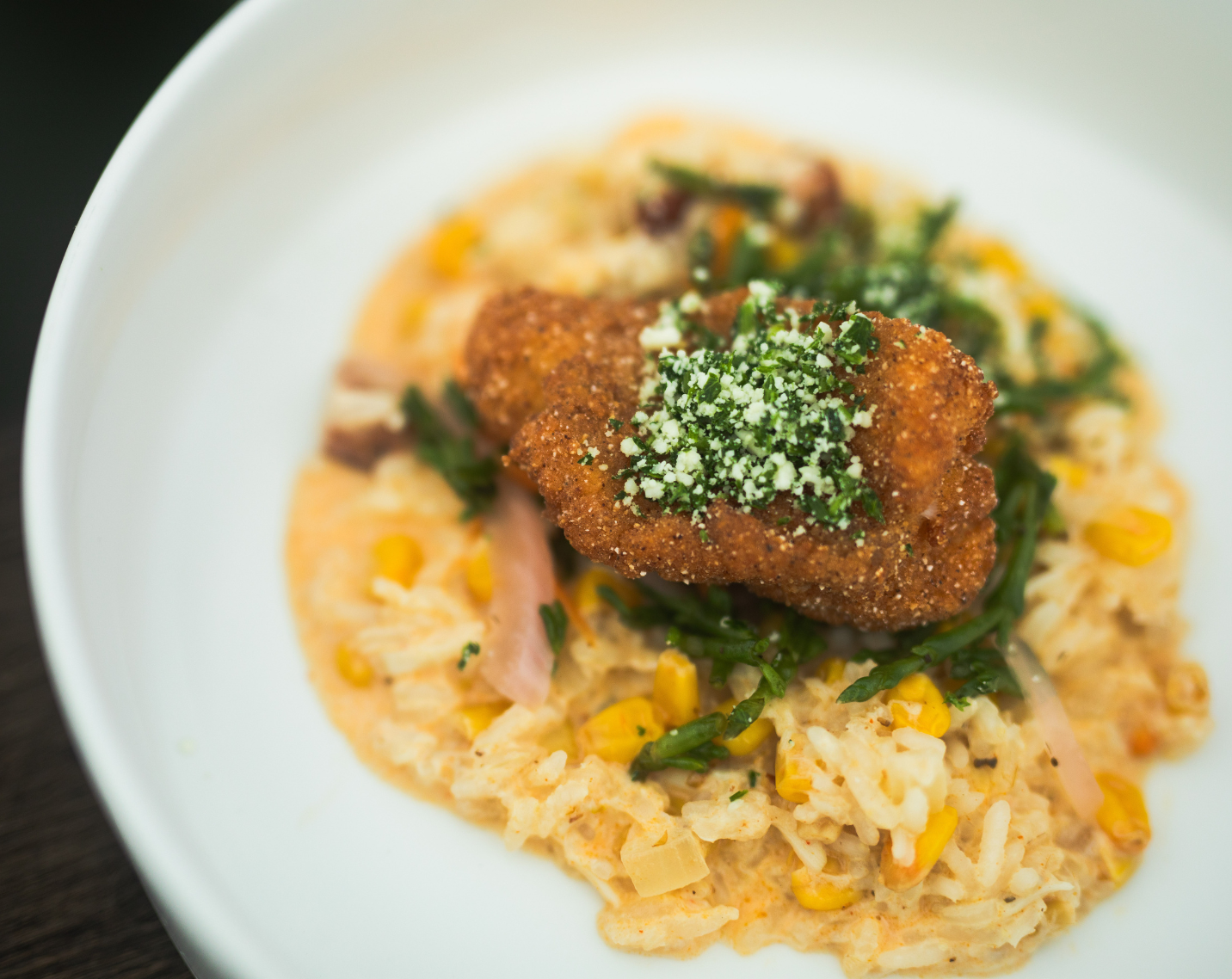 Carolina Classic featuring catfish, andouille sausage, Cajun crab risotto, pickled UNCW sea bean salad, and Cotija gremolata.