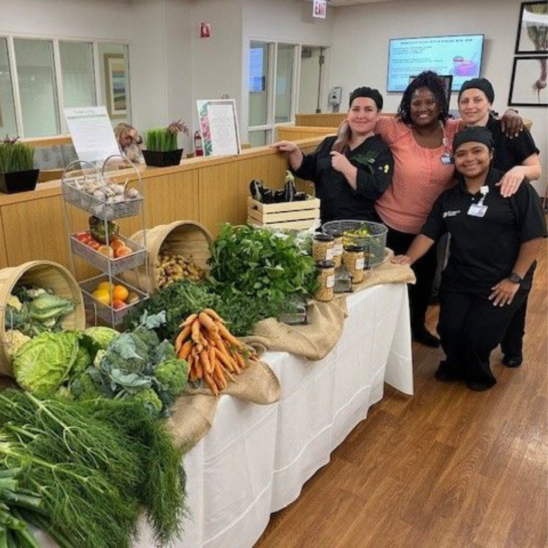A farmer's market stand with staff posing.