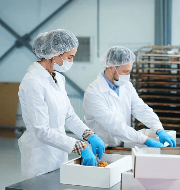 Two people packing boxes with bakery items