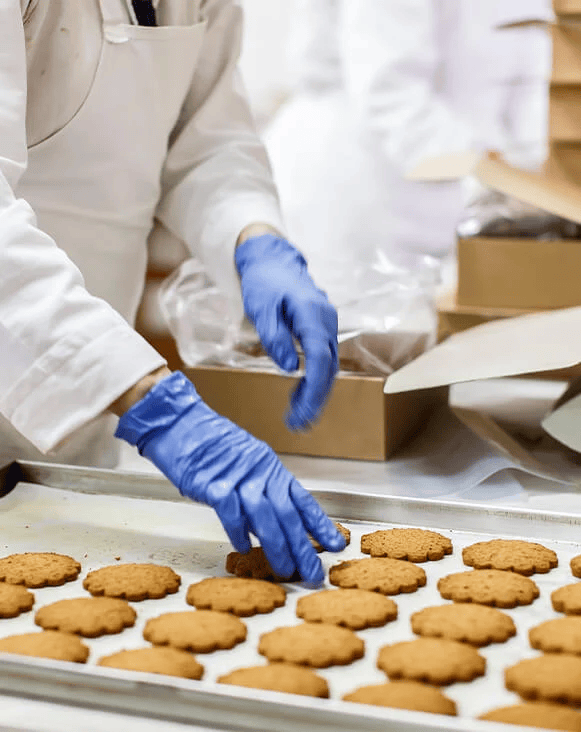 Person wearing gloves packing bakery items into a box