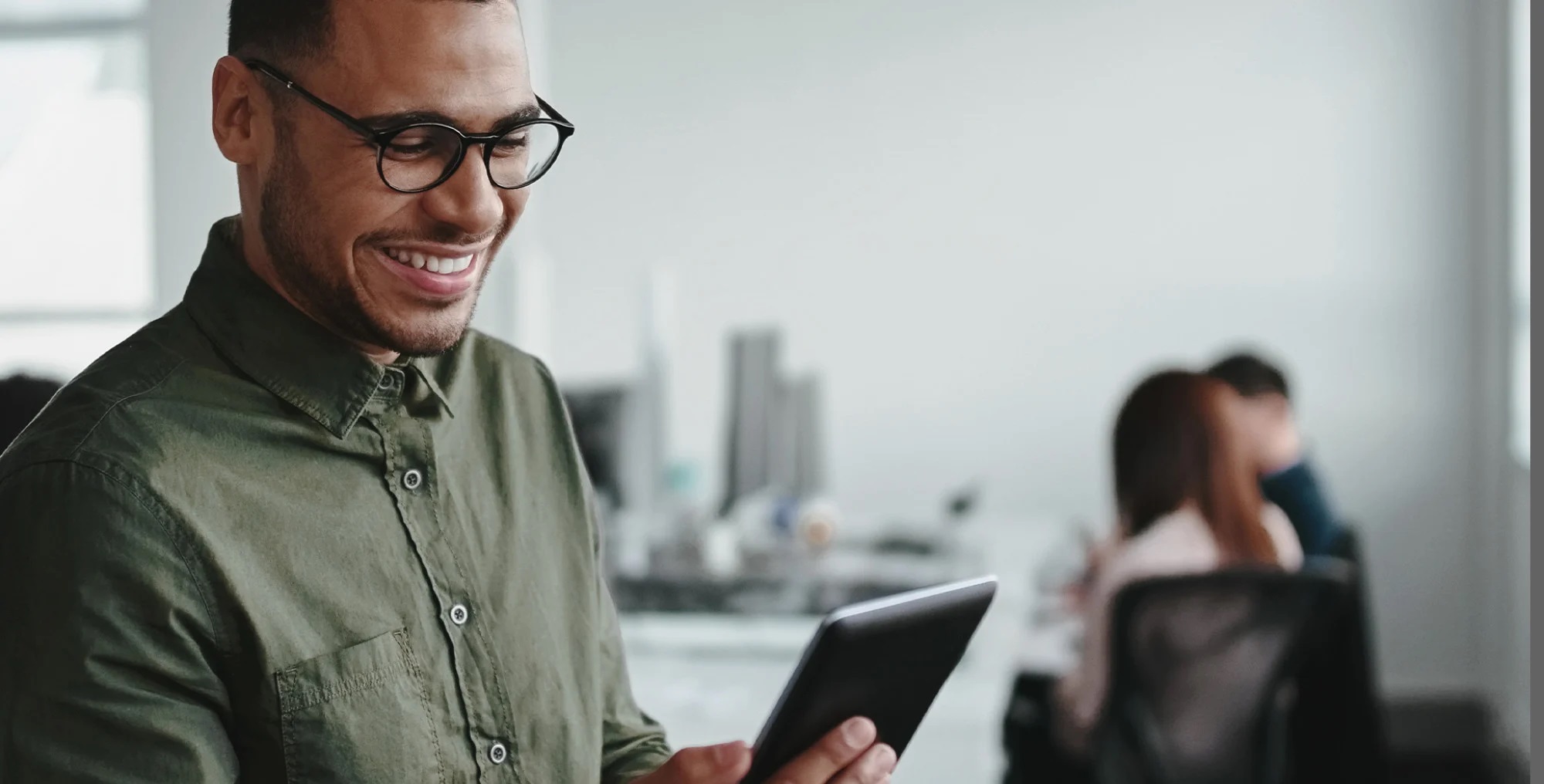 A smiling employee holding a tablet.