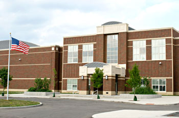 Front entrance of a school building with American flag on a pole