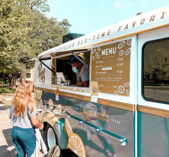 A food truck vendor taking an order from a customer.