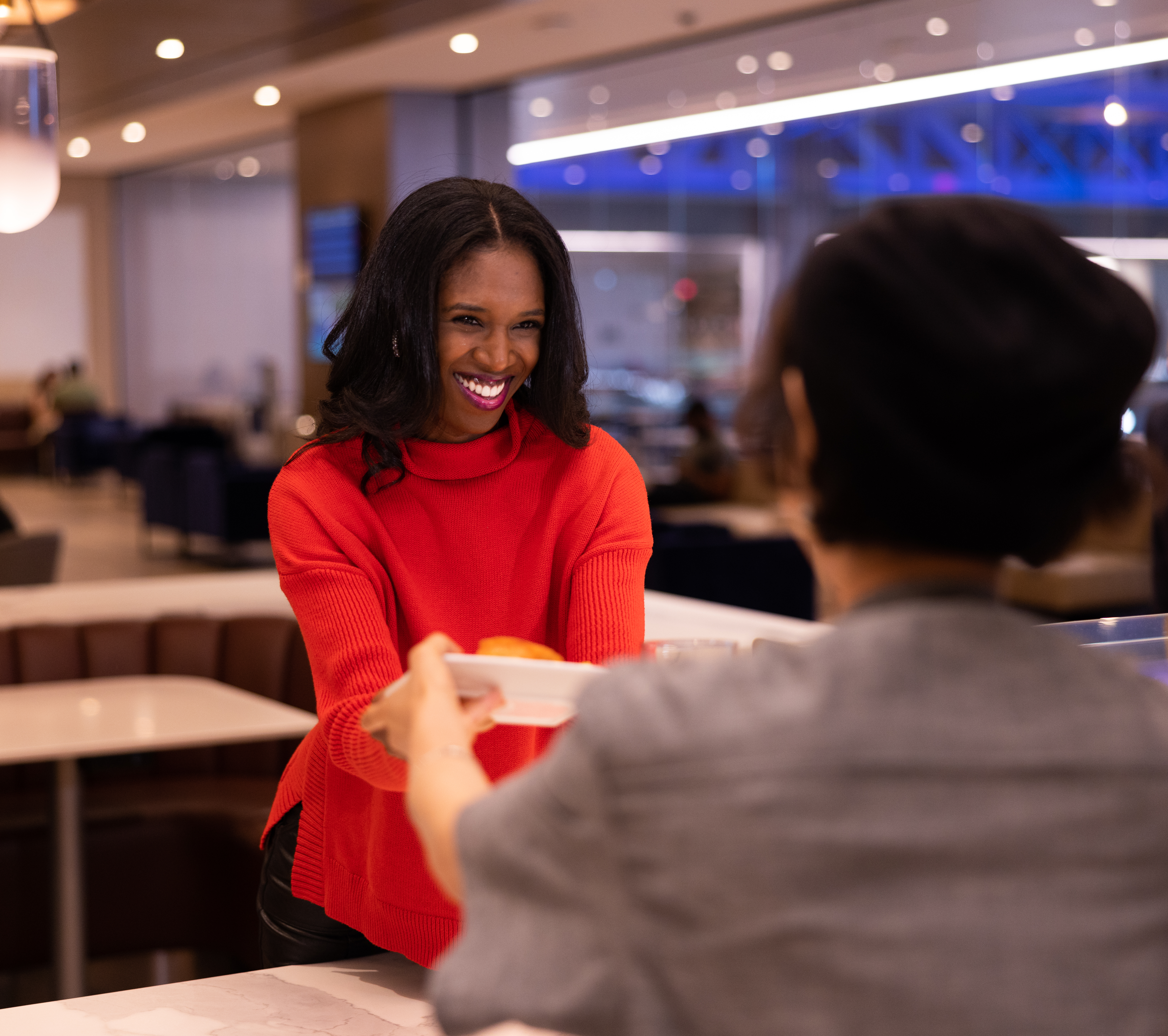 Woman in red getting handed food