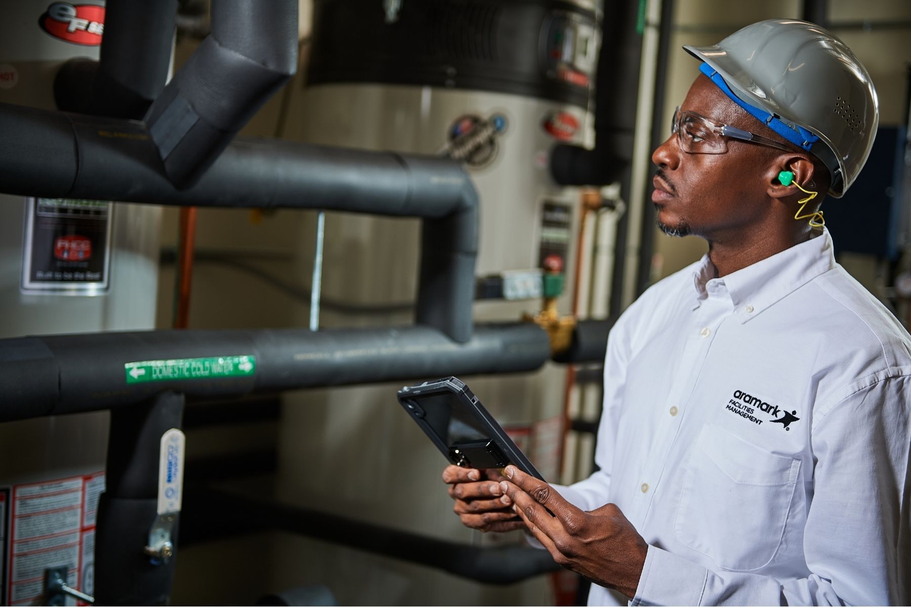 Man with tablet inspecting pipes