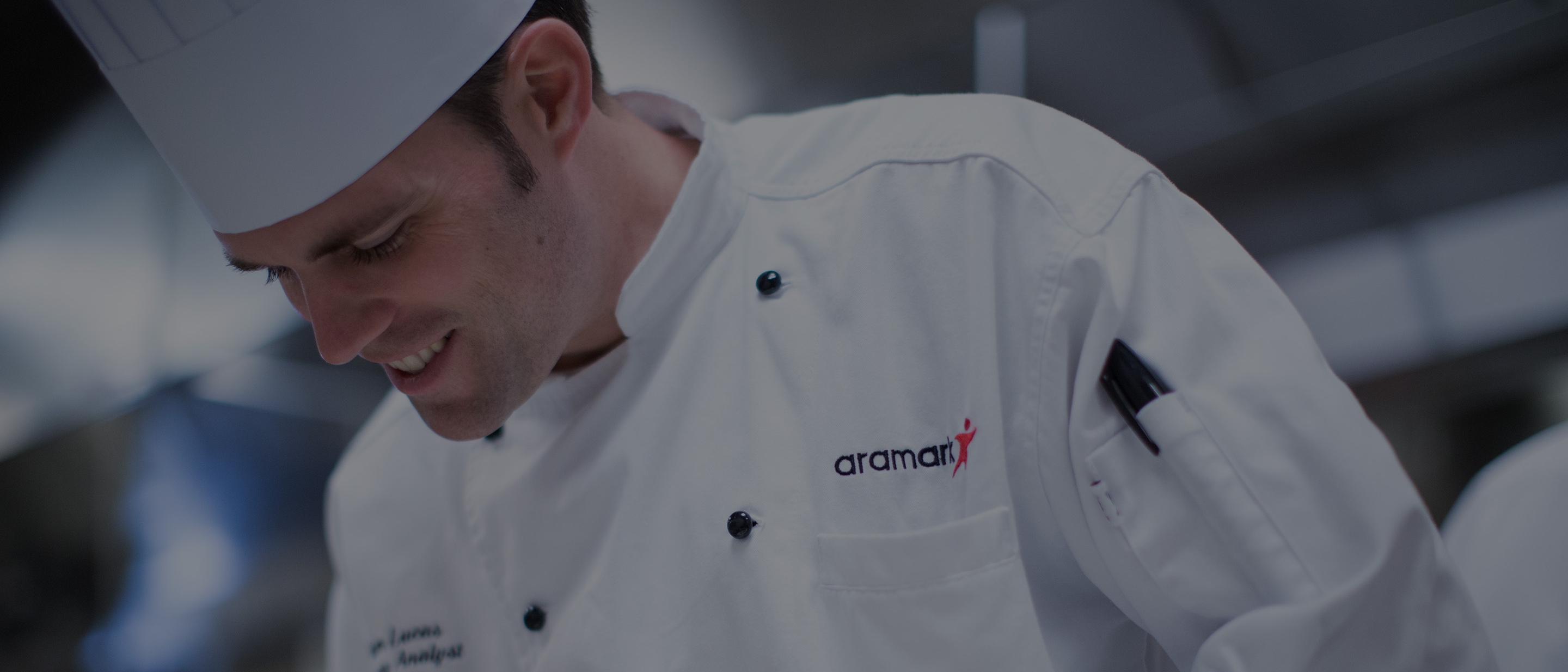 Chef smiling in Aramark uniform. 