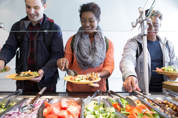 People serving themselves at a salad bar.