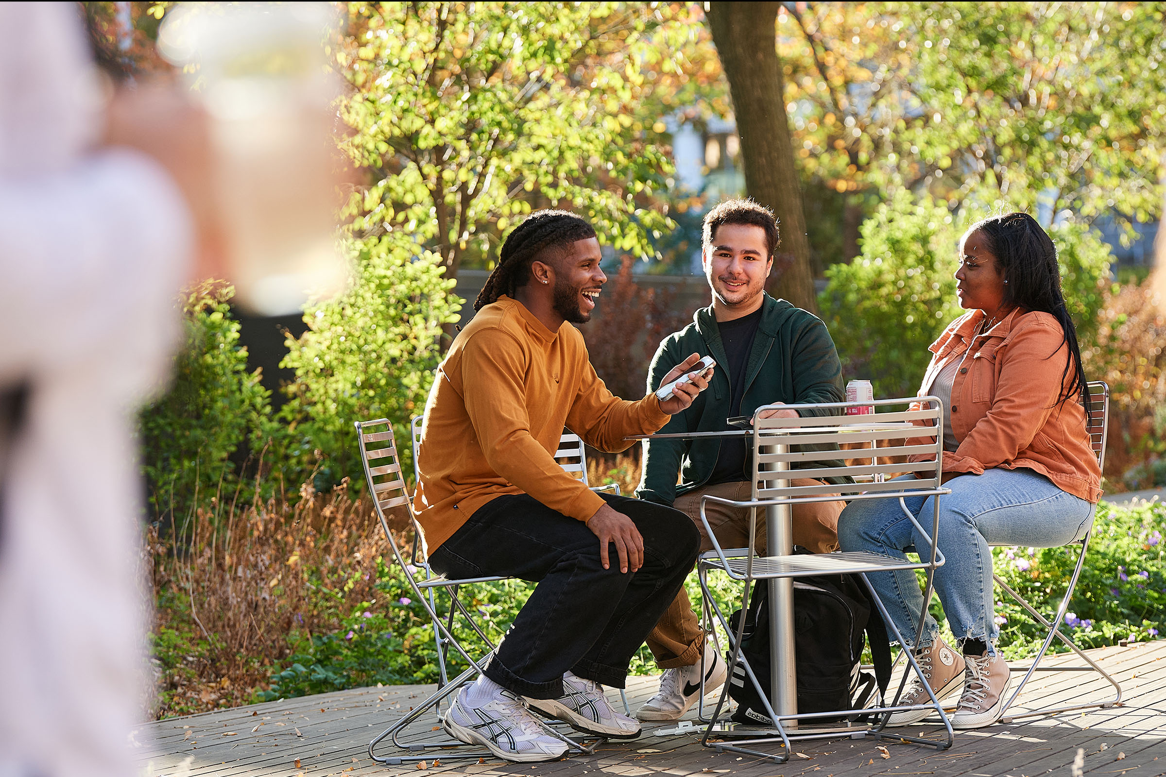 A group of college students talking and laughing while eating outside.