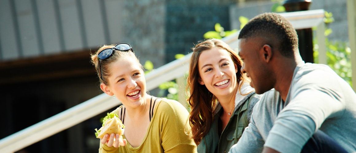 College students laughing and eating.