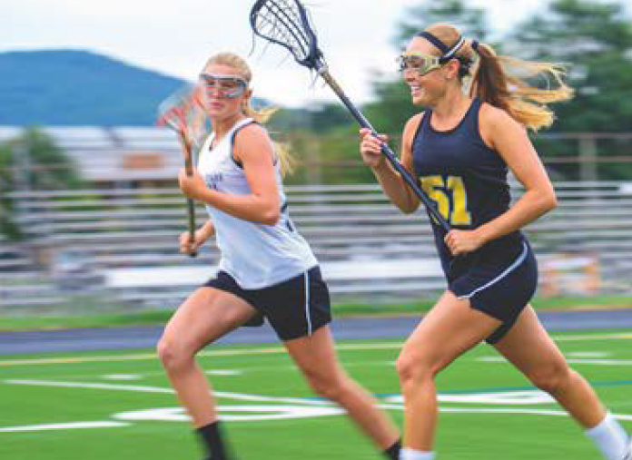 2 female lacrosse players run down field