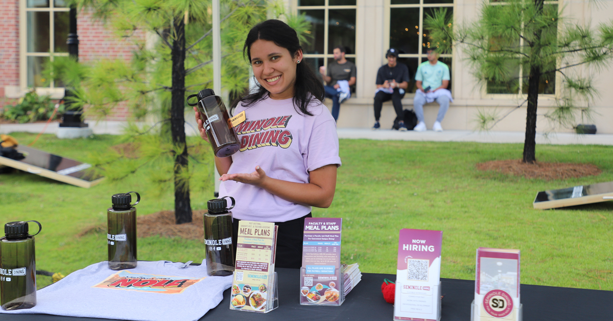 student handing out materials at table