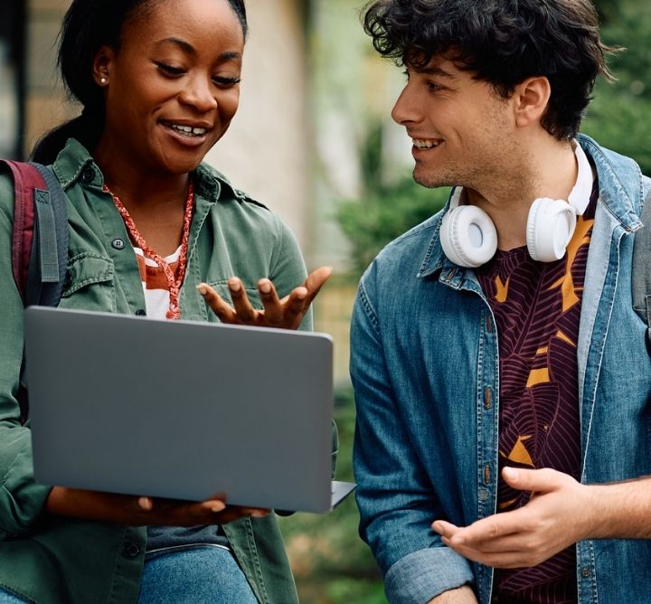 Students Chatting on Campus with a laptop.