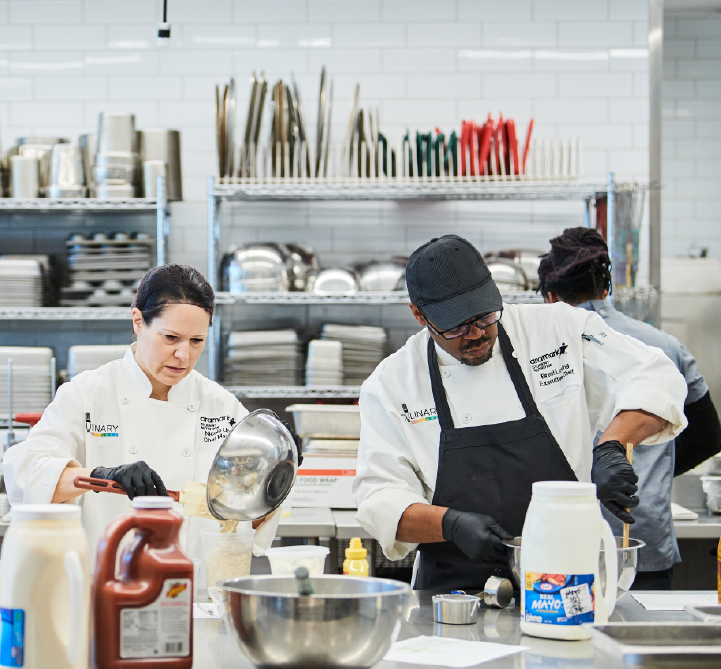 Two Aramark chefs preparing a meal.