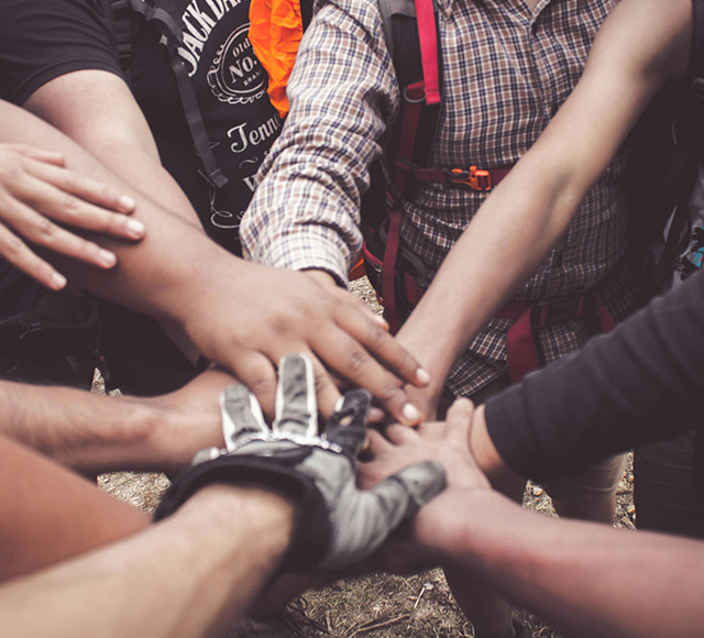 A group of people with their hands in the center.