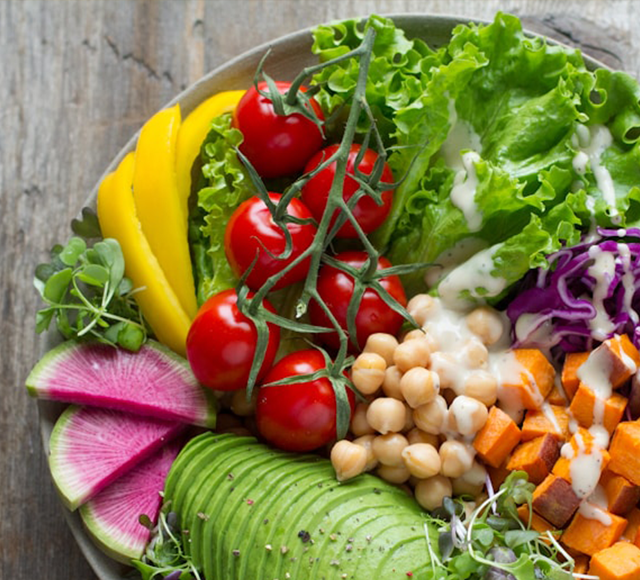 Fresh vegetables in a bowl with salad dressing.