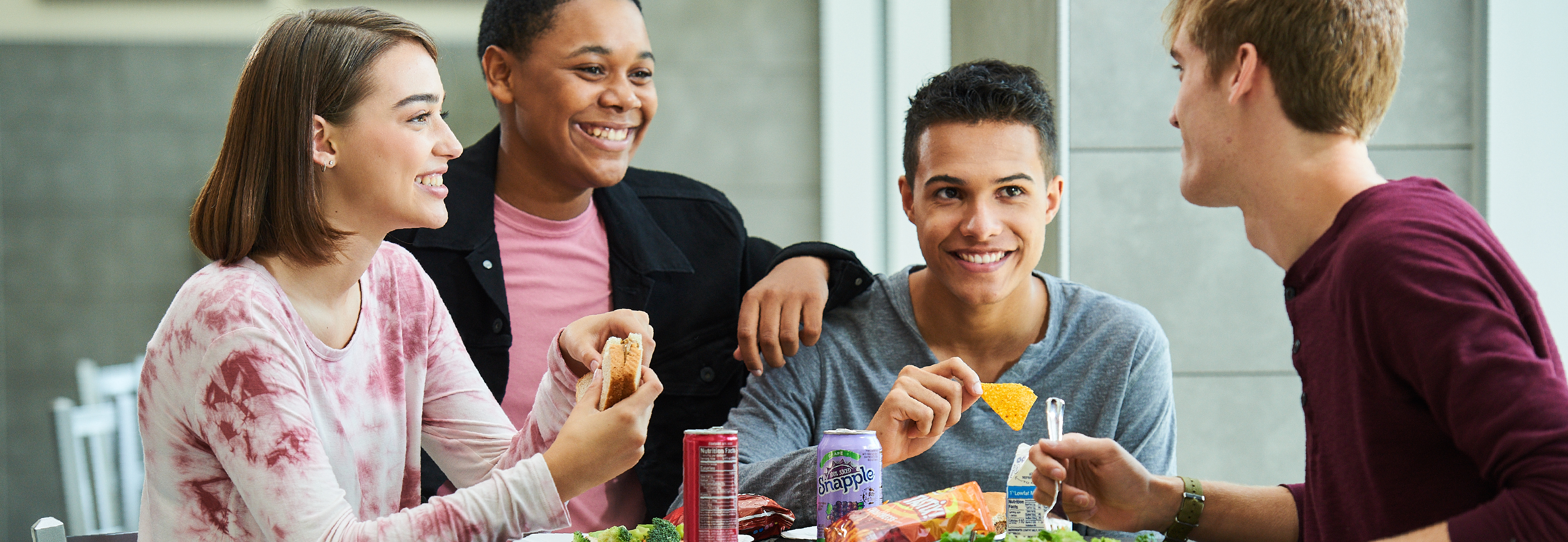High school students laughing and eating lunch.