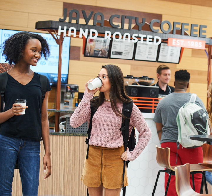 Two youbg women drinking coffee at a Java City Coffee store.