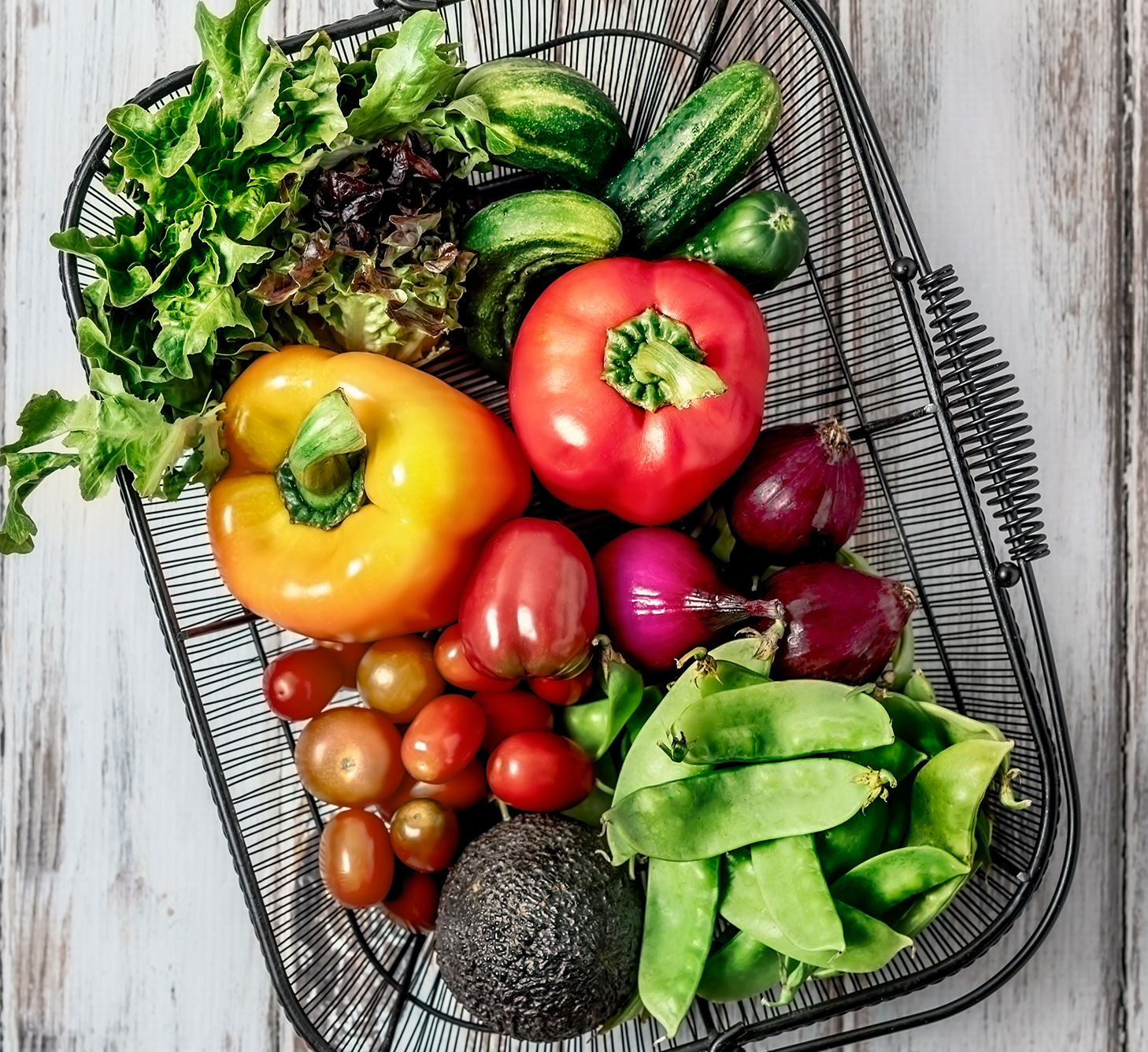 Fresh vegetables in a wire basket.