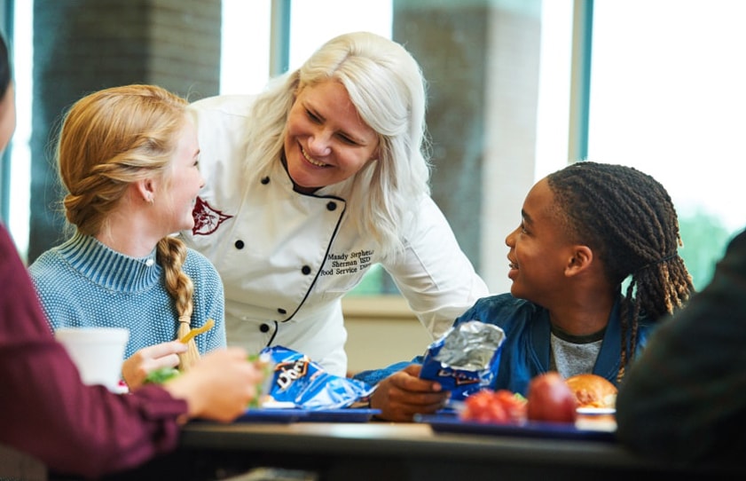 Chef talking and smiling with children.