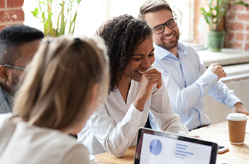 Employees talk and laugh in meeting room