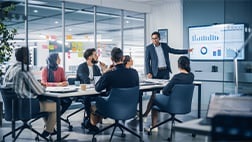 Corporate employees in a meeting room watching a presentation.