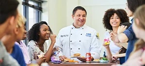 Chef talking to students at a lunch table.