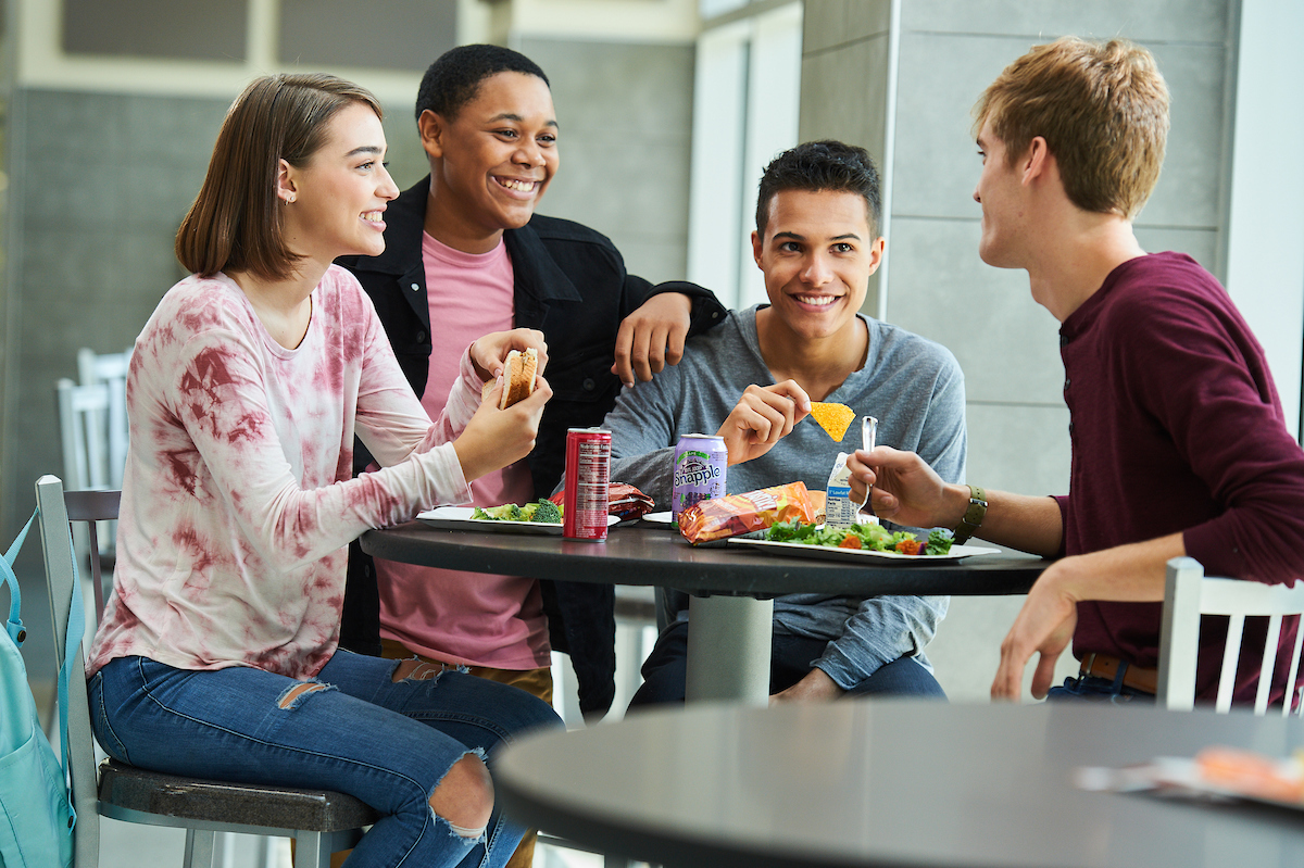 Students eating lunch together in a cafeteria.