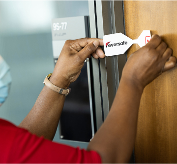 Staff member adding safety label to a door.