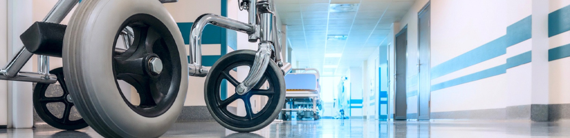 An empty wheelchair in the hallway of a hospital.