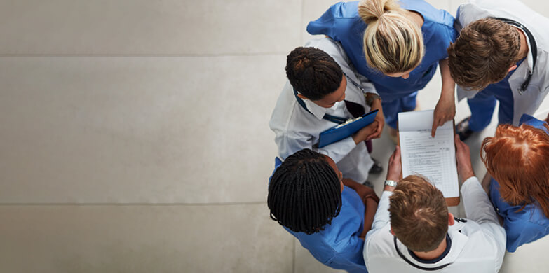 Healthcare professionals huddled around a medical chart.