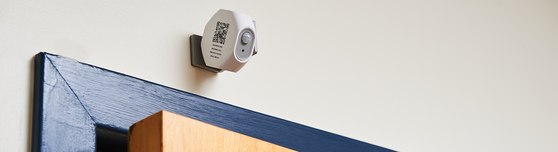 Wall-mounted occupancy sensor with a scannable QR code.
