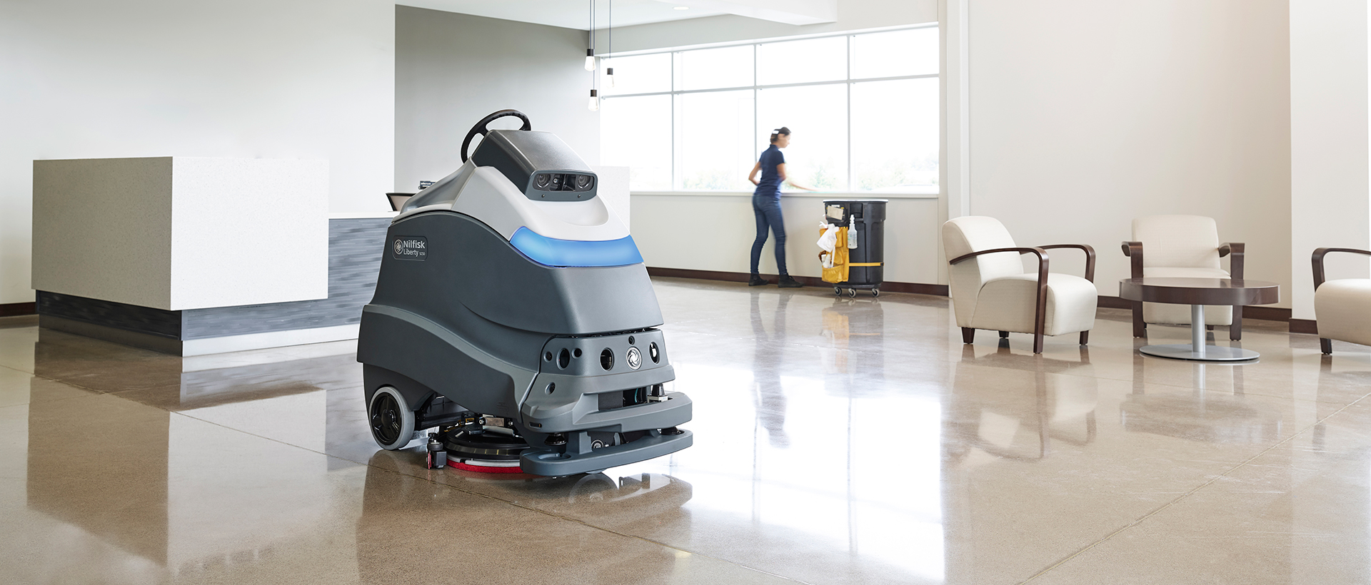 A Nilflisk floor-cleaning robot cleaning the tile floors of a lobby.