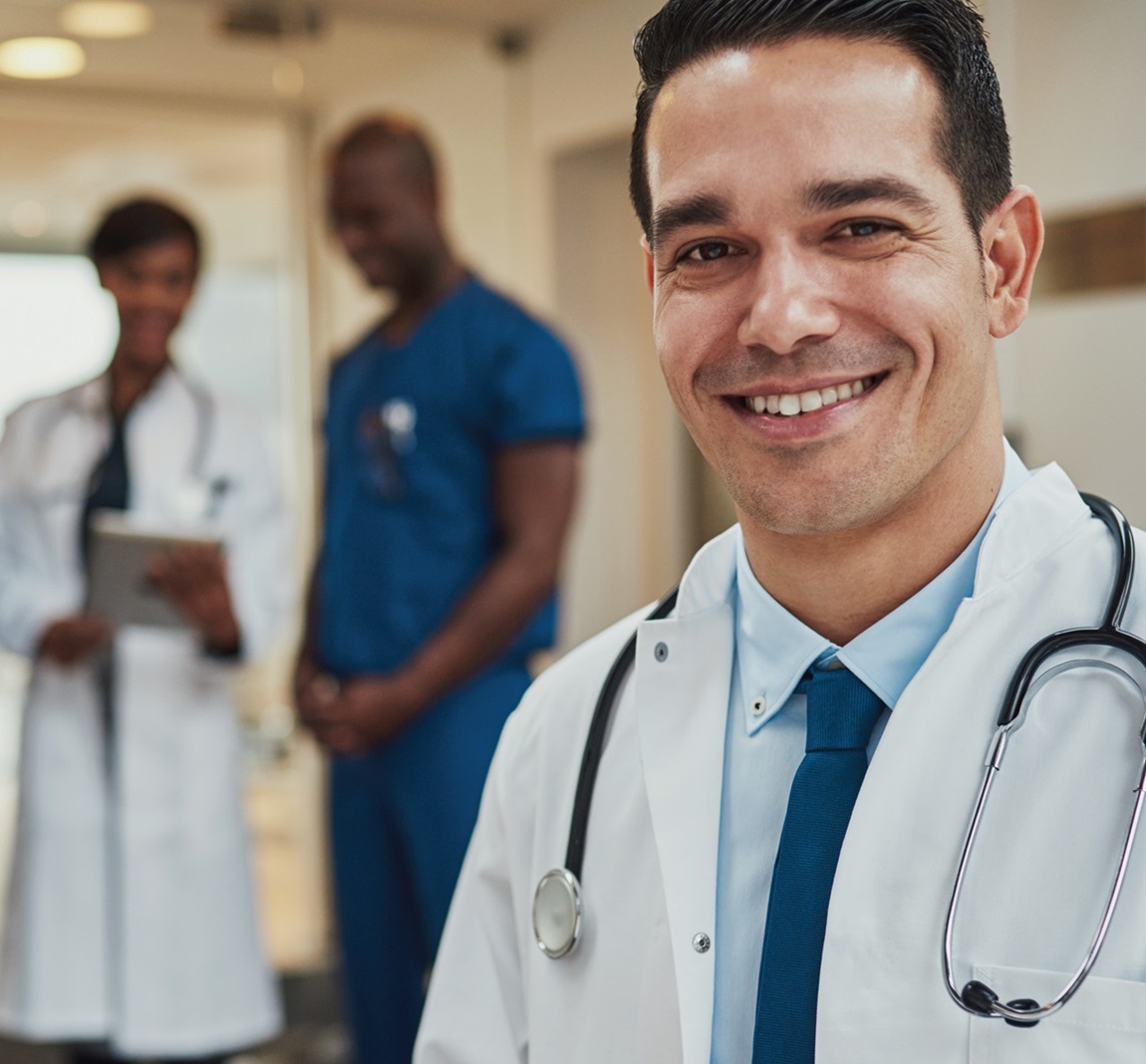 A smiling doctor wearing a labcoat and stethoscope.