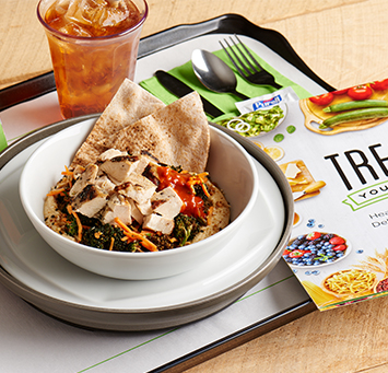 A bowl of salad and pita bread on a hospital food tray.
