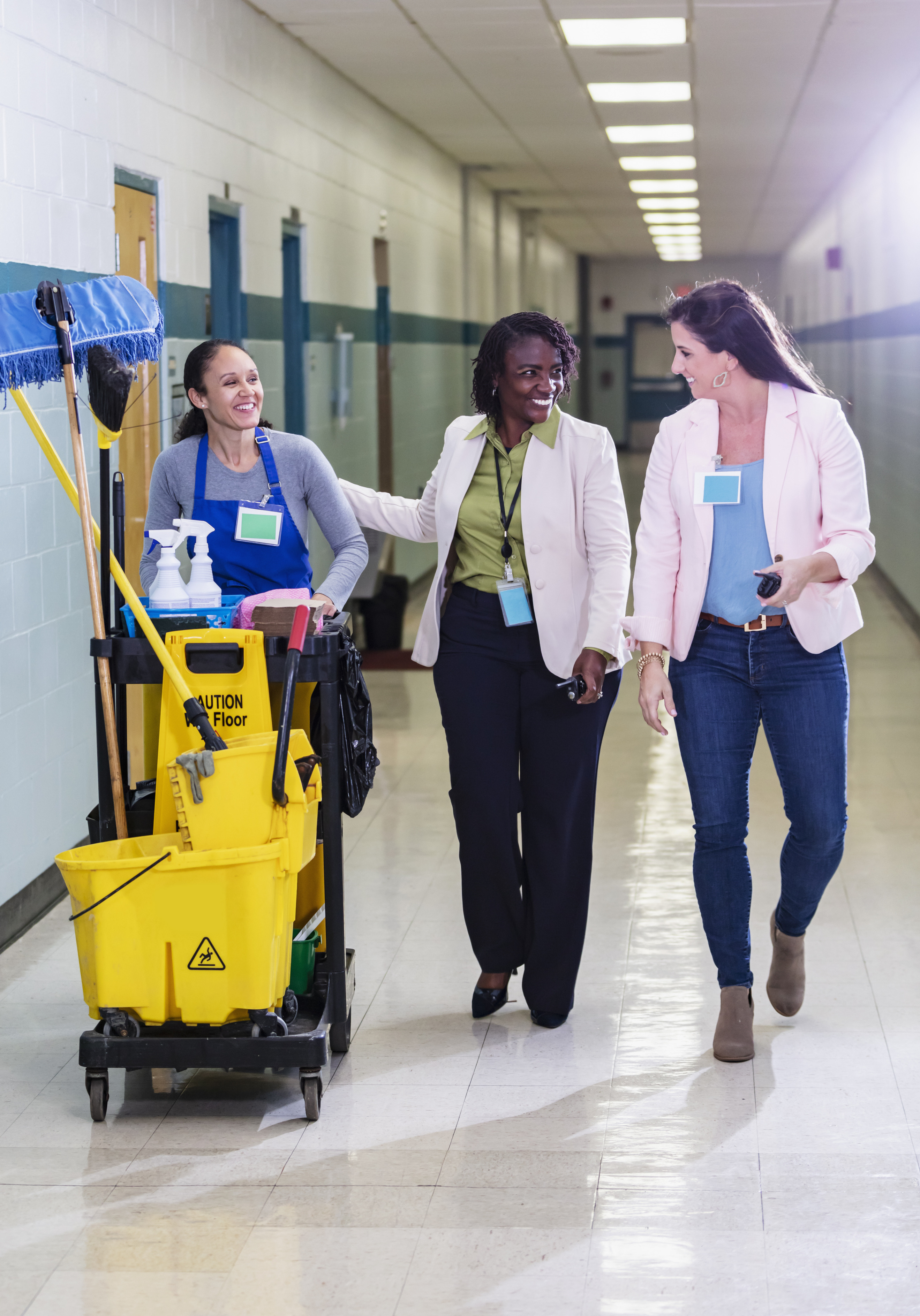 three people walking in hospital hallway