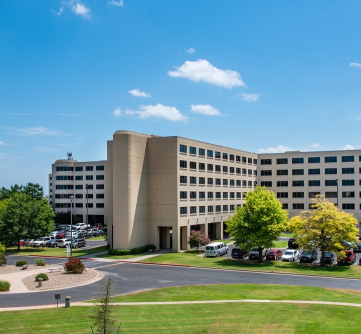 Exterior of a conference center complex and surrounding greenery.