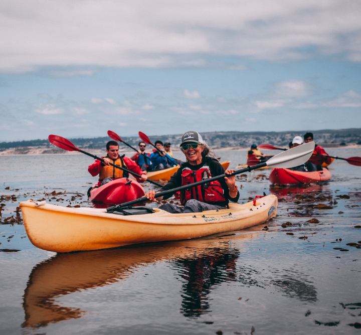 Smiling kayakers holding paddles.