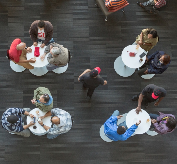 Visitors sitting and eating at small tables, served by Aramark staff.