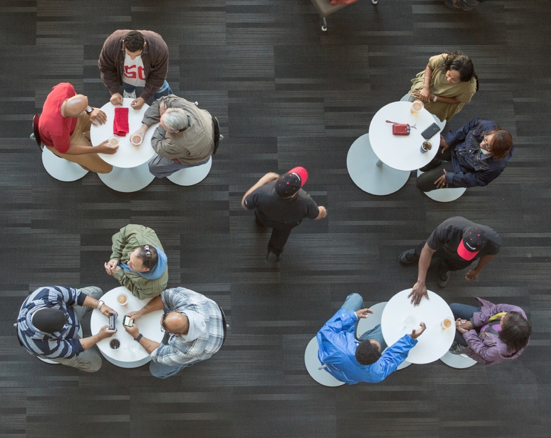 Visitors sitting and eating at small tables, served by Aramark staff.
