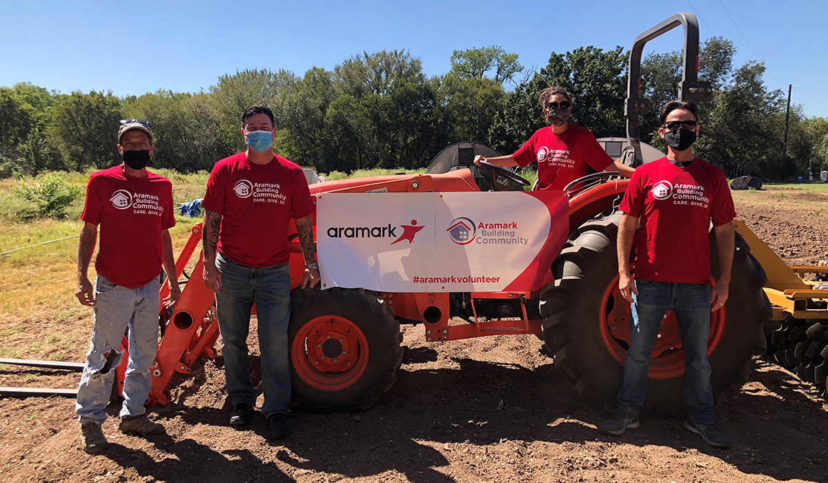 Aramark community workers around tractor