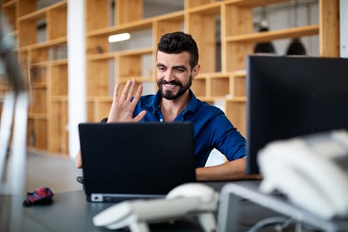 Man waving at computer